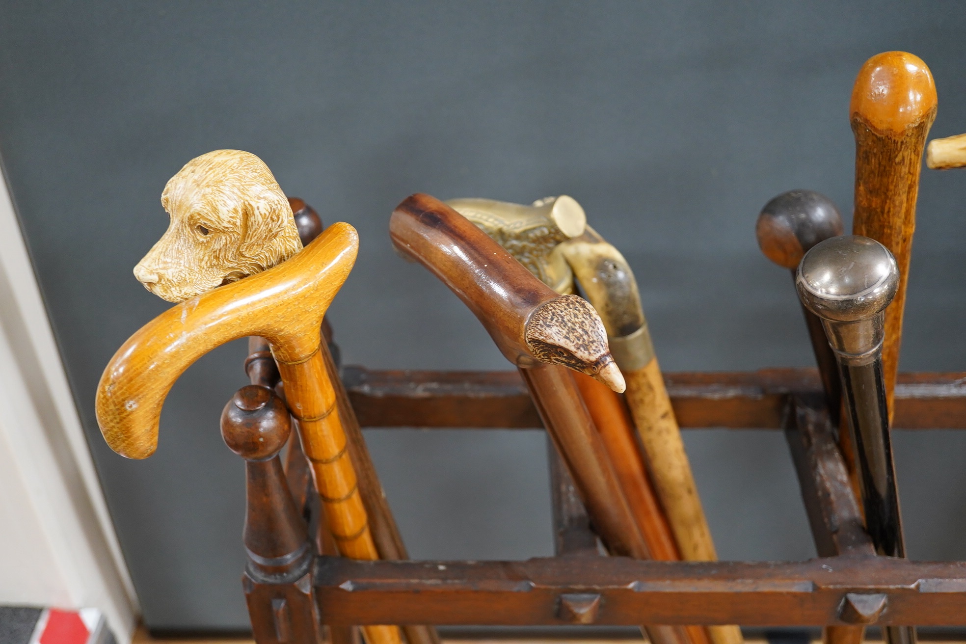 An Arts & Crafts oak umbrella stand and various walking sticks including two silver mounted. Condition - varies